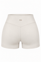 Beige high-waisted athletic shorts with a small 'ITVS' logo on the front waistband, shown against a plain white background.